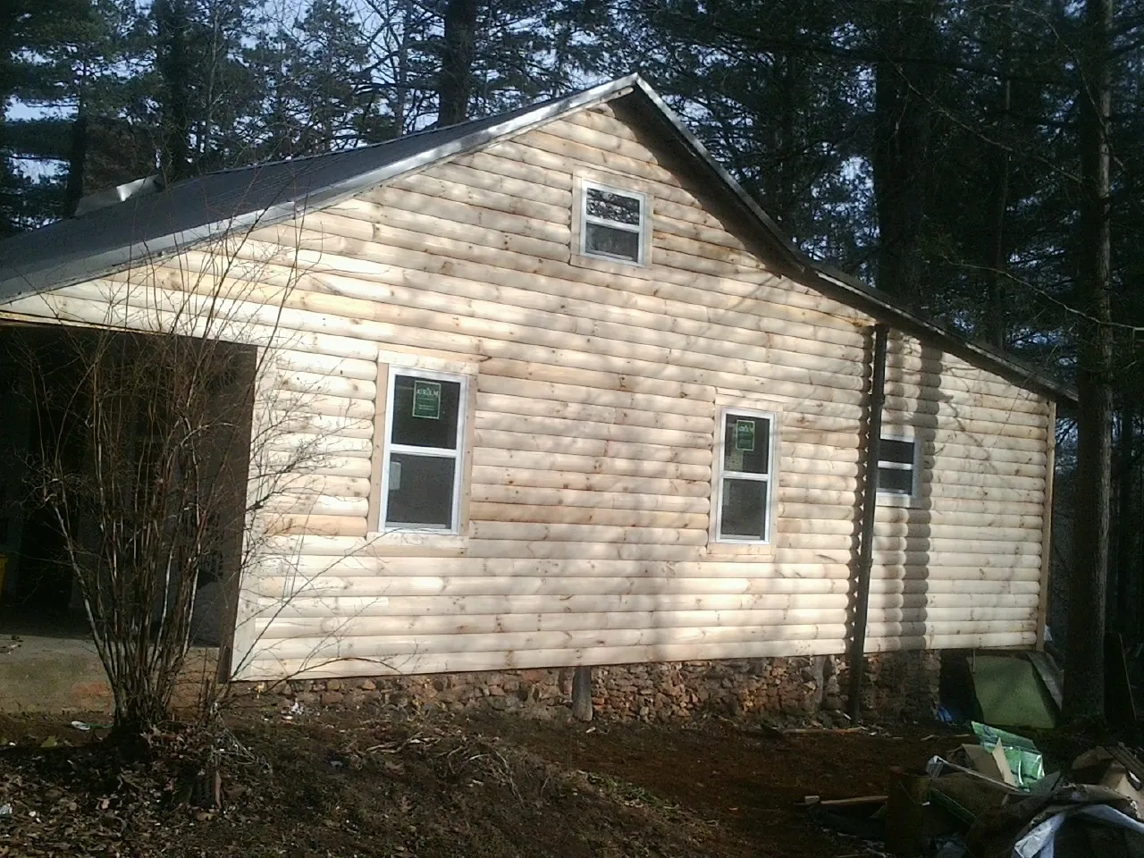 New log siding and dark metal roofing on a gable end in Rochester